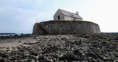 A picture of Cwyfan Church taken at low tide from the rock below